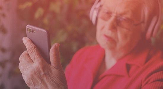 An elderly women wearing red holding a phone