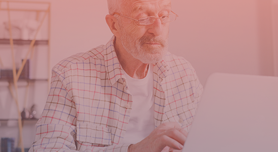 Elderly man looking at his computer