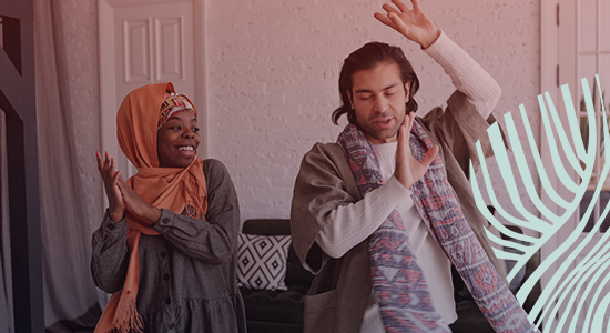 A young girl wearing a hijab and a man dancing joyfully in a living room, with a decorative light feature on the right side of the image, creating a warm and inviting atmosphere. 